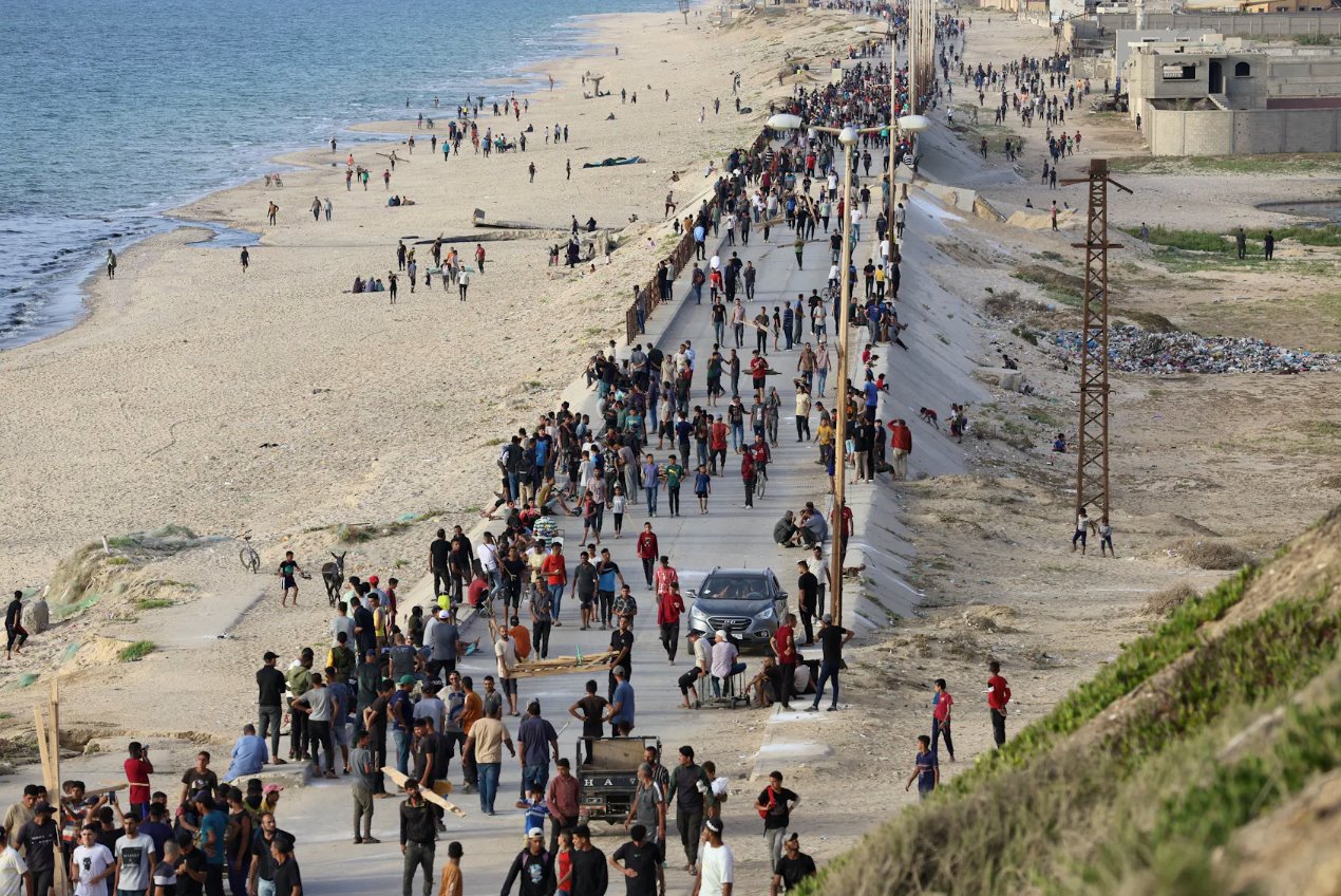 2024年5月19日加沙地带中部，巴勒斯坦人聚集在一起，希望通过美国建造的码头获得向加沙运送的援助。