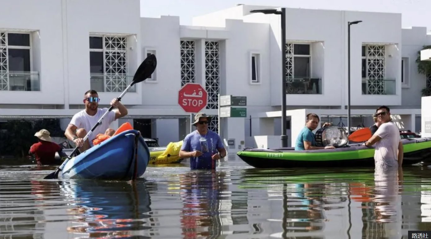 2024年4月，迪拜被洪水淹没的住宅区，居民用皮划艇搬运物品。