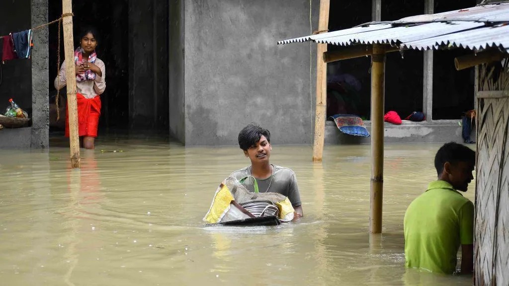 2024年7月1日，印度阿萨姆邦Nagaon地区发生强降雨后，人们正在将财物转移到更安全的地方。